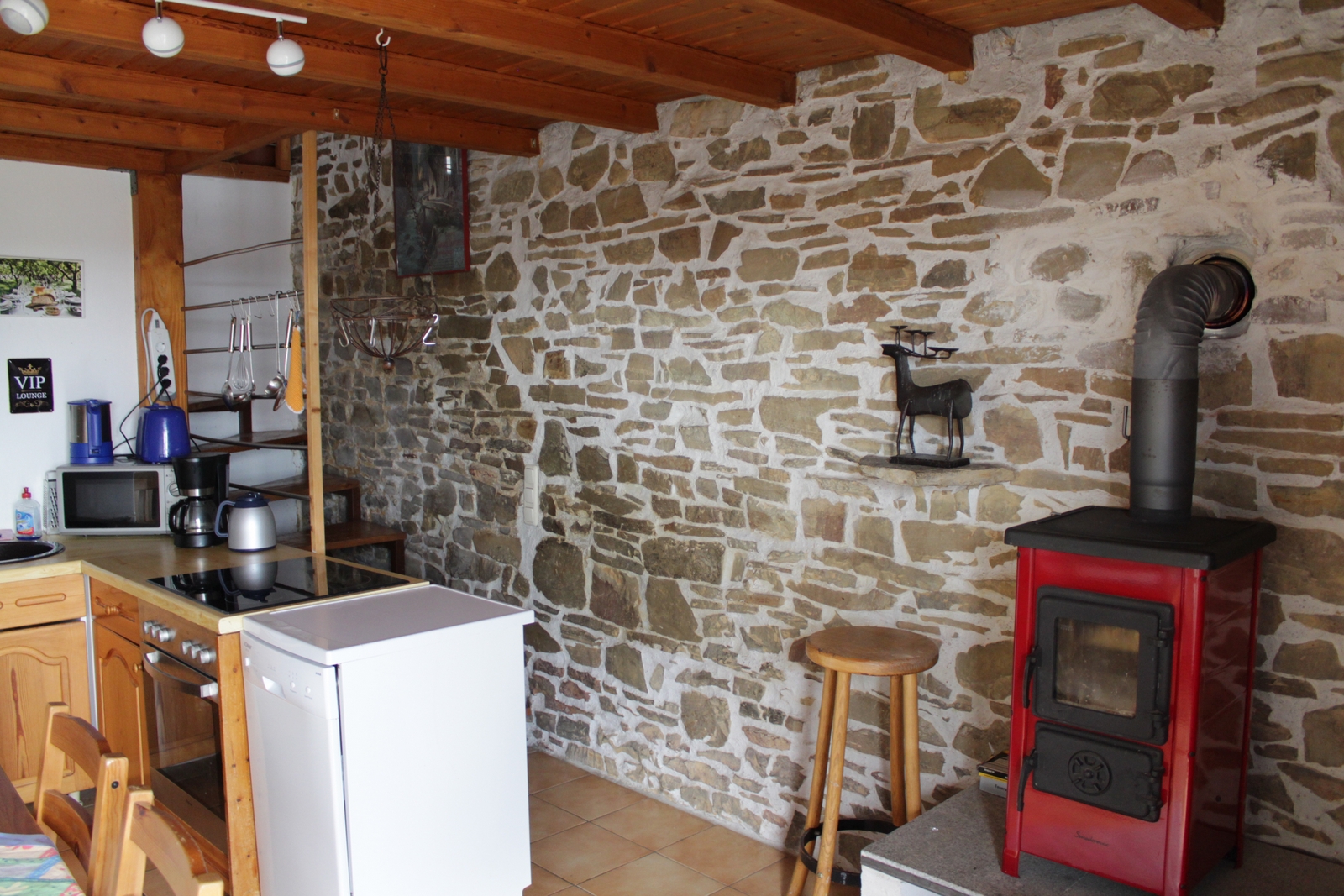 Studio Kochzeile mit Bruchsteinwand und Kaminofen